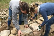 Zwei Frauen schichten eine Steinmauer auf