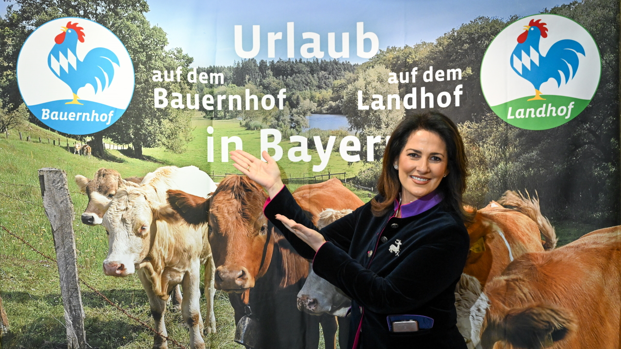 Ministerin Michaela Kaniber vor Plakat "Urlaub auf dem Bauernhof".