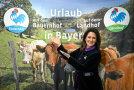 Michaela Kaniber vor dem Plakat Urlaub in Bayern 
