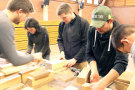 Studierende bearbeiten Holzklötze in Werkstatt