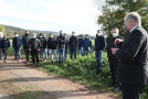 Mann erklärt Gruppe etwas auf einem Feldweg