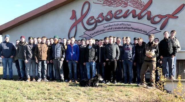 Personengruppe vor Gebäude mit Schriftzug "Hessenhof"